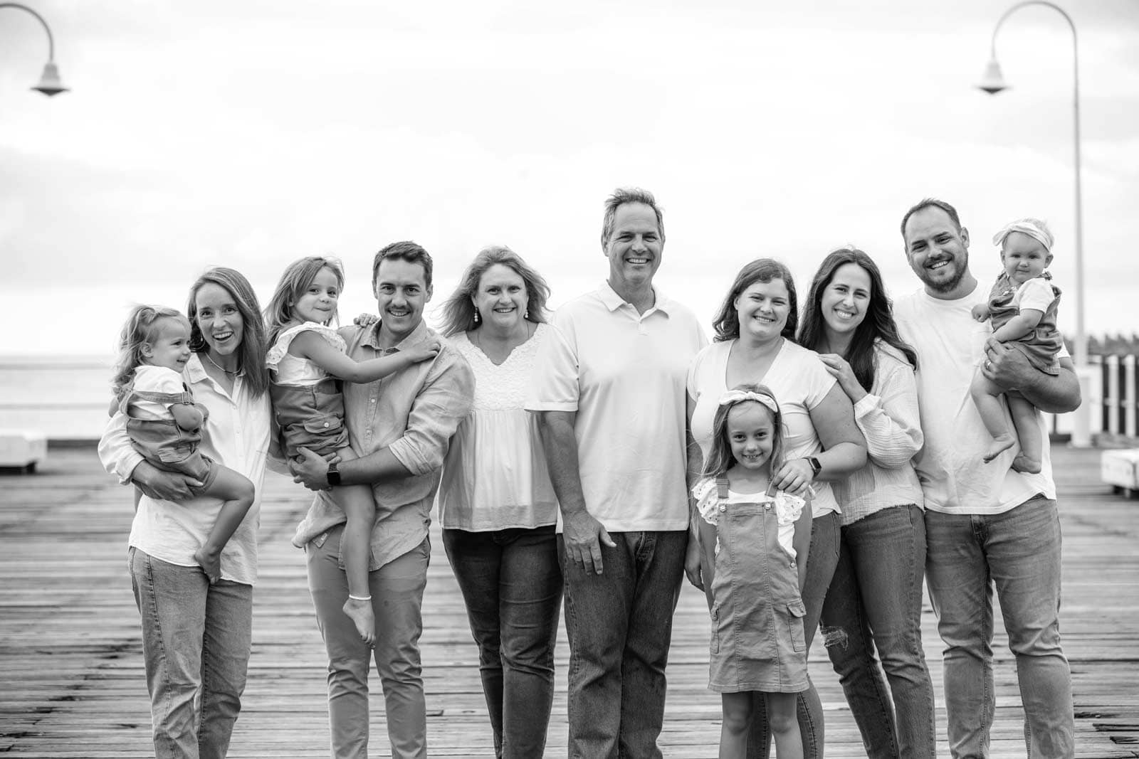 Black and white photo of Debbie's family on a timber jetty