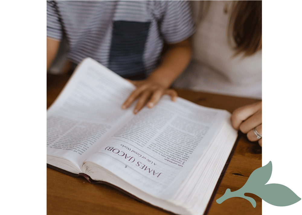 open bible with child and mother's hands