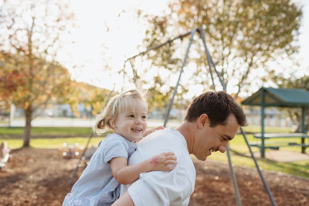Young Dad piggy-backing young daughter