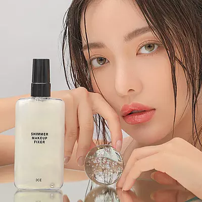 Applying 3CE shimmer makeup fixer mist for glowing radiant skin